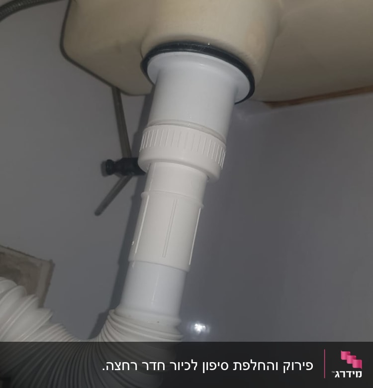 צינור פלסטיק לבן מתחת לכיור עם חיבור גמיש